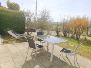 a glass table and chairs on a patio at Sonniges 2-Zimmer-Gartenapartment in Bietigheim-Bissingen