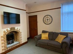 a living room with a couch and a fireplace at Rodsley - 2 bedroom 1st floor flat Free Parking WiFi and Netflix in Gateshead