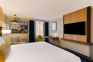 a hotel room with a bed and a flat screen tv at Best Western Premier the Central Hotel & Conference Center in Harrisburg