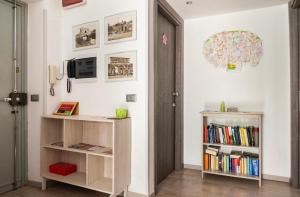 ローマにあるWhatsHouse Romaの本棚2つと壁掛けテレビ付きの部屋