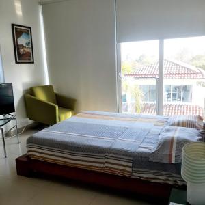 1 dormitorio con cama, ventana y silla en Rio Mar Villages, en San Carlos