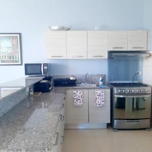 a kitchen with white cabinets and a stove top oven at Rio Mar Villages in San Carlos