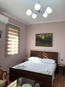a bedroom with a bed with a sink and a mirror at Villa Garden in Berat