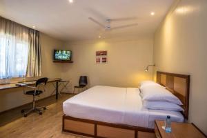 a bedroom with a bed and a desk and a television at Best Western Nairobi Upper Hill in Nairobi
