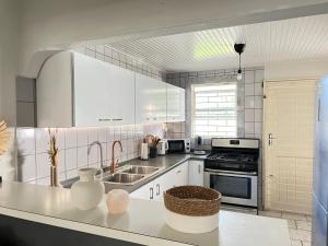 a kitchen with white cabinets and a sink at Casa Augusto in Willemstad