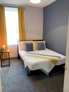 Heaton-Beautiful 3 Double Bedrooms Sleeps 6 Free Parking and Wifi في نيوكاسل أبون تاين: غرفة نوم بسرير كبير وبها وسائد زرقاء وصفراء