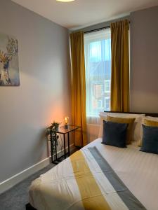 a bedroom with a bed and a window with a candle at Heaton-Beautiful 3 Double Bedrooms Sleeps 6 Free Parking and Wifi in Newcastle upon Tyne