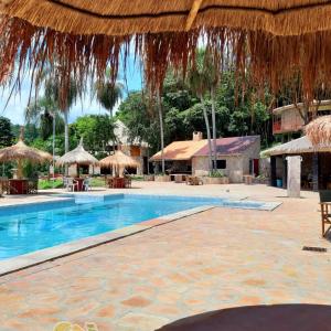 a resort with a swimming pool and straw umbrellas at Resort Sport in Independencia