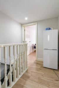 a kitchen with a white refrigerator and a staircase at Comfy Friendly Stay in London