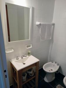 uma casa de banho branca com um lavatório e um WC em Hermoso departamento en el corazón de Palermo Soho em Buenos Aires