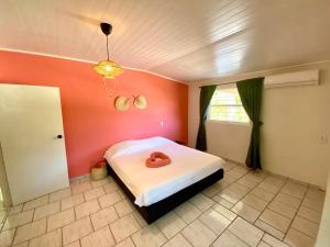 a bedroom with a bed with a pink wall at Casa Augusto in Willemstad