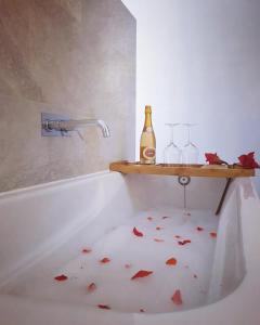 a bathroom with a bath tub with red leaves on the floor at Herdade dos Sepol in Odivelas