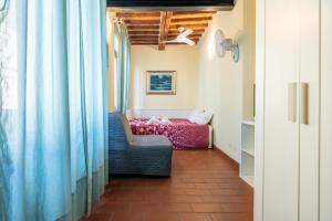 een kamer met een bed, een stoel en een raam bij Appartamento La Torre Pendente in Pisa