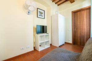 een woonkamer met een televisie en een deur bij Appartamento La Torre Pendente in Pisa