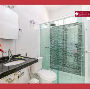 een badkamer met een toilet en een glazen douche bij Hotel Dunas Village Cumbuco in Cumbuco