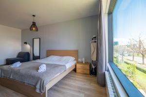 a bedroom with a bed and a large window at Arcadia Apartment, Park and Parking in Sofia