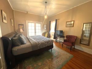 ein Schlafzimmer mit einem Bett, einem Sofa und einem Stuhl in der Unterkunft The Holiday Chalet Victorian in Denver