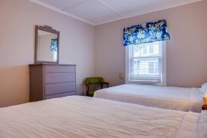 a bedroom with two beds and a mirror and a window at Ocean Terrace Family Apartments in Ocean City