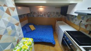 um pequeno quarto com uma cama azul numa cozinha em CASA VACANZE DI MARILENA em Vietri