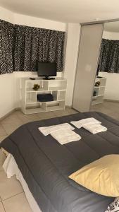 1 dormitorio con 1 cama grande y toallas. en Departamento TIERRA V en Salta