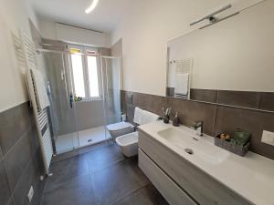 a bathroom with a sink and a toilet and a shower at Lux Family Apartment in Bardolino