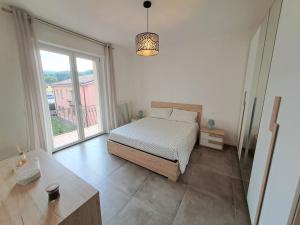 1 dormitorio con cama y ventana grande en Lux Family Apartment, en Bardolino