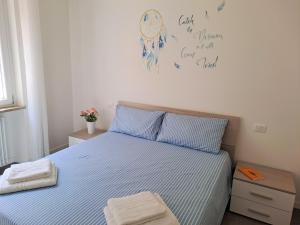 1 dormitorio con 1 cama con rayas azules y blancas en Lux Family Apartment, en Bardolino