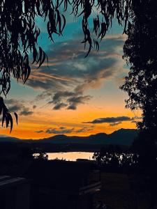 una puesta de sol sobre un cuerpo de agua con el cielo en Camping Las Acacias, en Guatavita