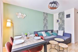 a living room with a blue couch and a table at Appartement cosy, idéalement situé en centre-ville in Les Sables-d'Olonne