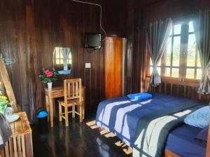 a bedroom with two beds and a table and a chair at สุขเสมอ โฮมสเตย์ (Suk-Samer homestay) 