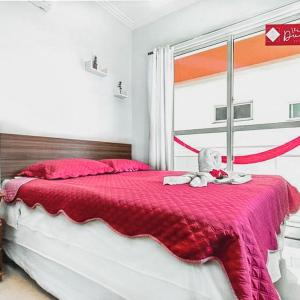 een bed met een rode deken en een knuffel erop bij Hotel Dunas Village Cumbuco in Cumbuco