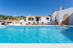 a villa with a swimming pool in front of a house at Casa da Soalheira in São Brás de Alportel