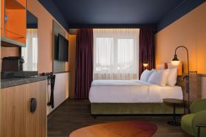 um quarto de hotel com uma cama e uma cozinha em Mayburg Salzburg, a Tribute Portfolio Hotel em Salzburgo