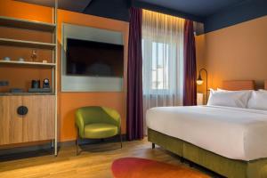 una camera d'albergo con letto e sedia verde di Mayburg Salzburg, a Tribute Portfolio Hotel a Salisburgo