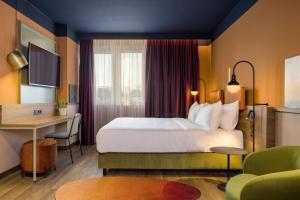 um quarto de hotel com uma cama e uma secretária em Mayburg Salzburg, a Tribute Portfolio Hotel em Salzburgo
