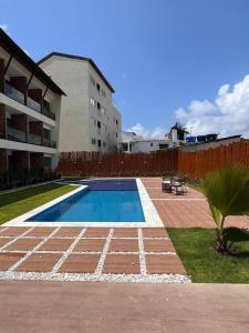 ein Pool in einem Hof neben einem Gebäude in der Unterkunft Flats em Condominio Velas do Porto in Porto De Galinhas