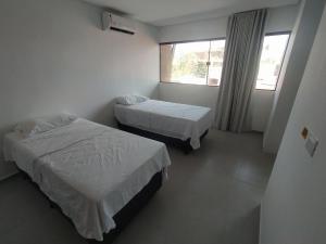 ein Hotelzimmer mit 2 Betten und einem Fenster in der Unterkunft Flats em Condominio Velas do Porto in Porto De Galinhas