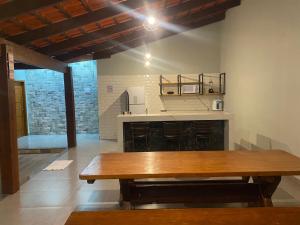 a wooden table in a room with a fireplace at Casa Ametista in Pirenópolis