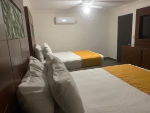 1 Schlafzimmer mit 2 Betten und einem Deckenventilator in der Unterkunft HOTEL DORADO DIAMANTE in Mexicali
