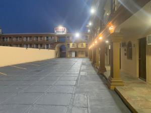 an empty parking lot in front of a building at night at Hotel Dorado Baja in Mexicali