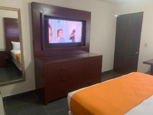 a bedroom with a tv on top of a dresser at Hotel Dorado Baja in Mexicali +43 photos