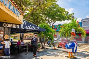 a group of people standing on a sidewalk in front of a restaurant at Coral Gable Studio & House Free Parking & Wifi in Miami