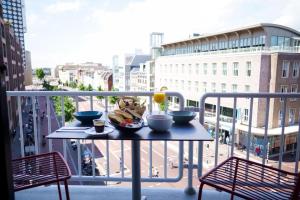 un tavolo con ciotole di cibo su un balcone di Leonardo Hotel Utrecht City Center a Utrecht