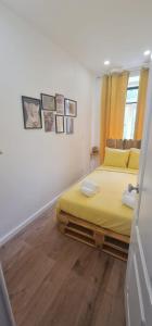 a bedroom with a yellow bed and a wooden floor at S.Soares Yellow Beato in Lisbon