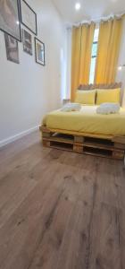 a bedroom with two beds and a wooden floor at S.Soares Yellow Beato in Lisbon