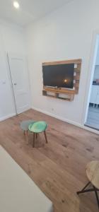 S.Soares Yellow Beato في لشبونة: غرفة معيشة مع طاولة وتلفزيون بشاشة مسطحة