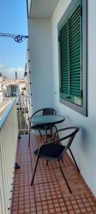 stół i krzesło na balkonie z oknem w obiekcie Azores House w mieście Ponta Delgada