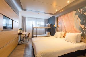 een hotelkamer met een bed en een stapelbed bij Leonardo Hotel Almere City Center in Almere