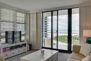 a living room with a couch and a tv at Cozy Coastal Condo with Pool Access Steps to Beach! in Marco Island