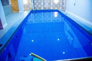 a large swimming pool with blue tiles on the floor at Aviel Suites in Rubuchi
